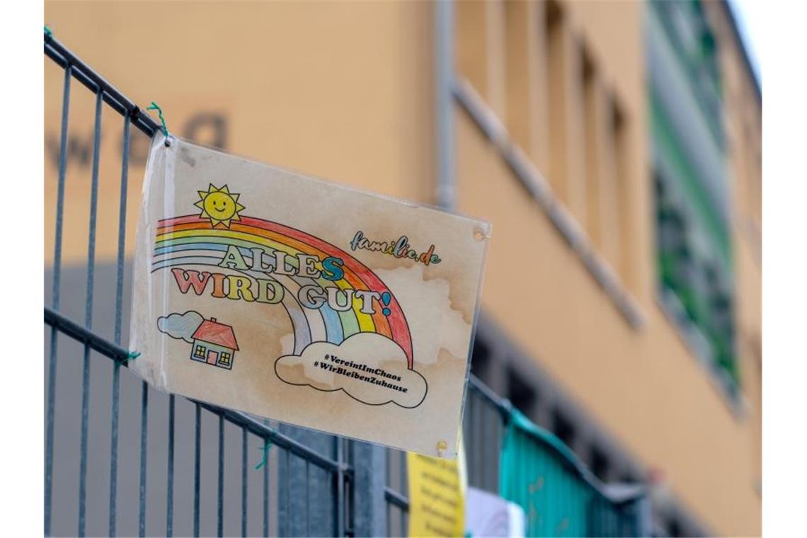 Kultusminister beraten über Schule nach den Sommerferien Ein Schild mit den Aufschriften „Alles wird gut!“ und „#VereintImChaos“ sowie „#WirBleibenZuhause“ hängt am Zaun einer Grundschule. Foto: Klaus-Dietmar Gabbert/dpa-Zentralbild/dpa