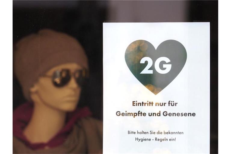 Ein Schild mit der Aufschrift „2G - Eintritt nur für Geimpfte und Genesene“ hängt im Schaufenster eines Modegeschäftes in Potsdam. Foto: Soeren Stache/dpa-Zentralbild/dpa