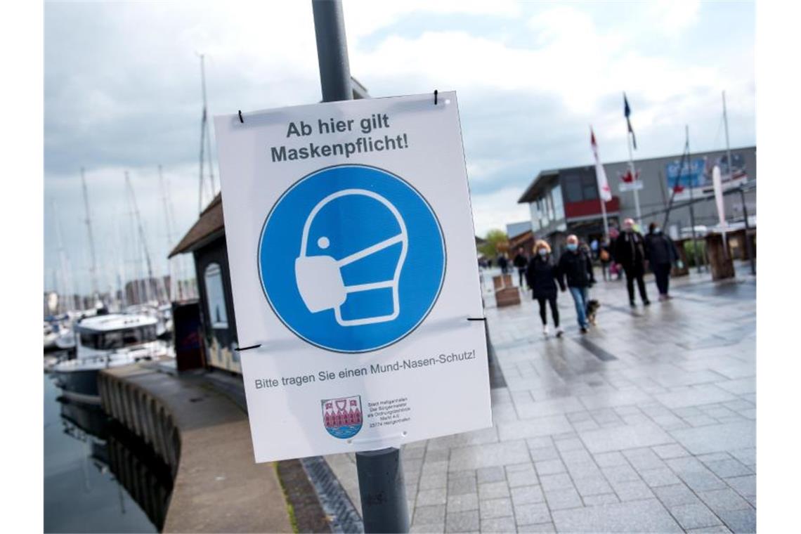 RKI: 7082 Corona-Neuinfektionen - Inzidenz bei 66,8 Ein Schild mit der Aufschrift „Ab hier gilt Maskenpflicht“ hängt an der Promenade. Foto: Daniel Bockwoldt/dpa