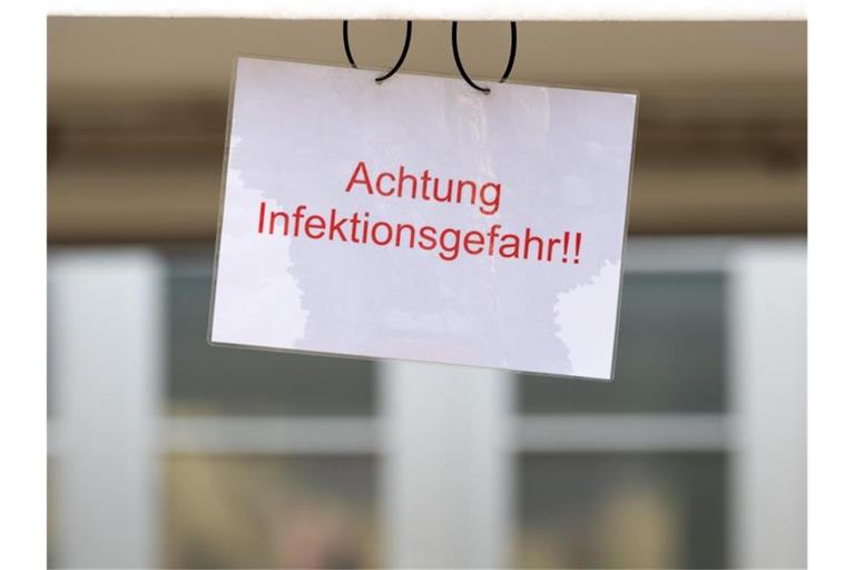 Ein Schild mit der Aufschrift „Achtung Infektionsgefahr!“ an einem Johanniter-Zelt in Brandenburg. Foto: Soeren Stache/dpa-Zentralbild/dpa
