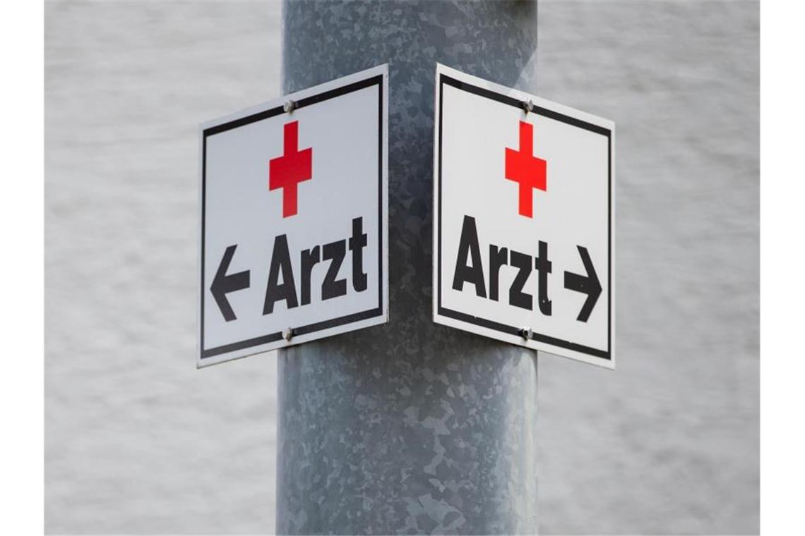 Ein Schild mit der Aufschrift „Arzt“ an einer Straßenlaterne. Foto: Tom Weller/dpa/Symbolbild