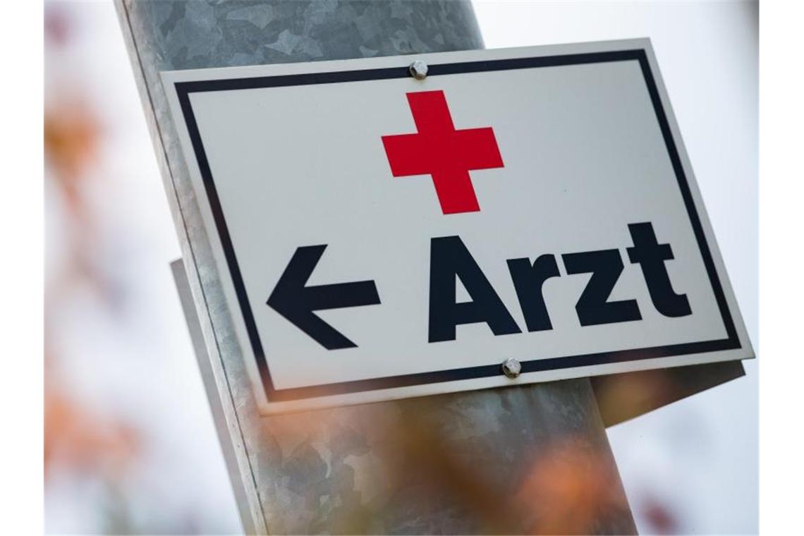 Ein Schild mit der Aufschrift „Arzt“ hängt an einer Straßenlaterne. Foto: Tom Weller/dpa/Archivbild
