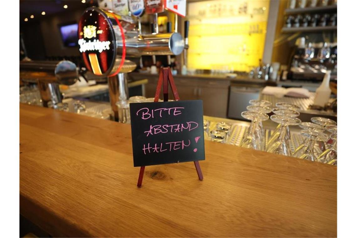 Ein Schild mit der Aufschrift "Bitte Abstand halten" steht auf dem Tresen im Köstritzer Bierhaus. Foto: Bodo Schackow/dpa-zentralbild/dpa