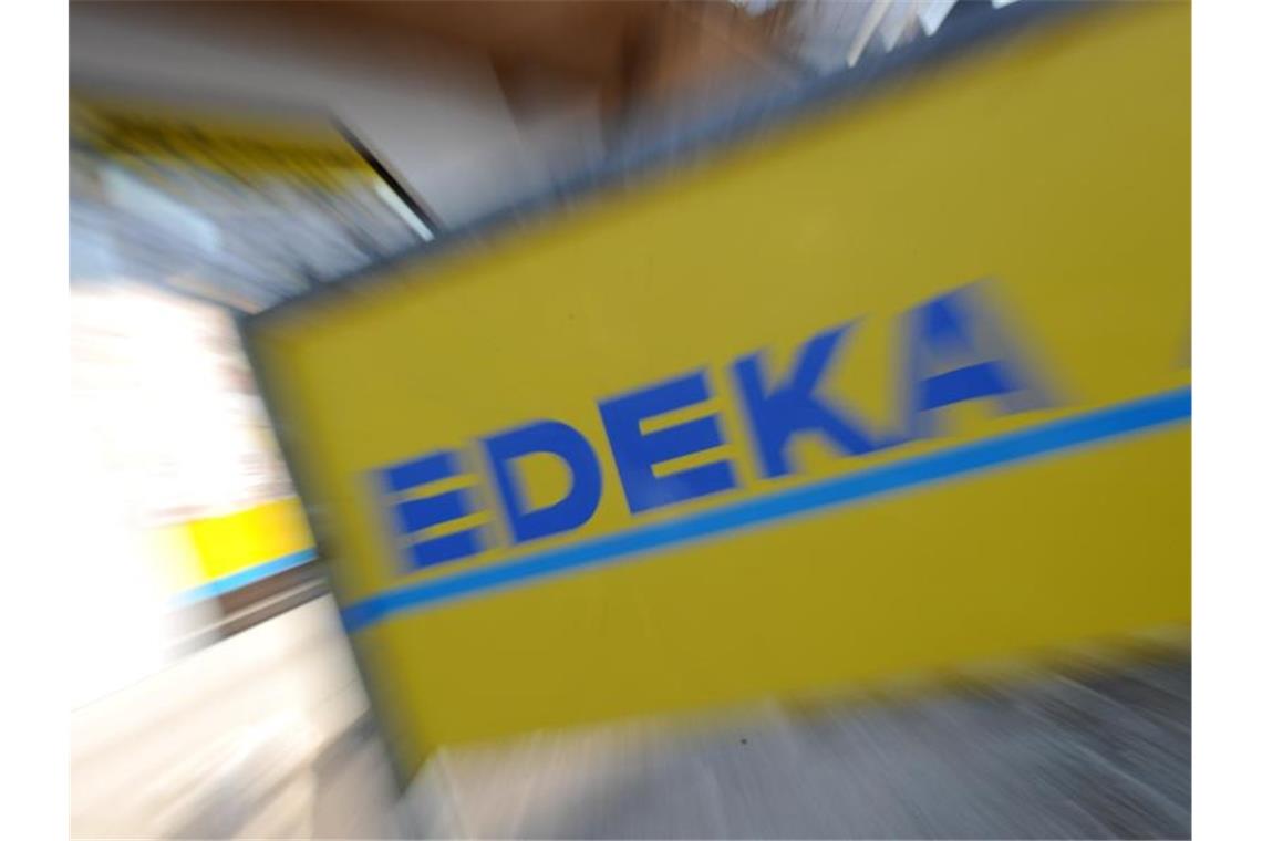 Ein Schild mit der Aufschrift „Edeka“. Foto: Tobias Hase/dpa/Archivbild