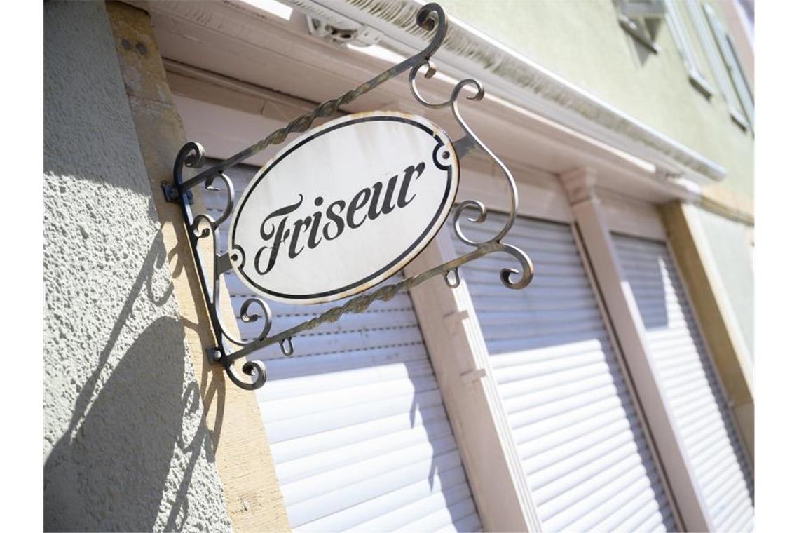 Ein Schild mit der Aufschrift „Friseur“ hängt an einem geschlossenen Friseursalon. Foto: Sebastian Gollnow/dpa/Archivbild
