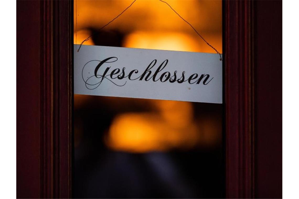 Ein Schild mit der Aufschrift "Geschlossen" hängt an einer Eingangstür. Foto: Rolf Vennenbernd/dpa/Archivbild