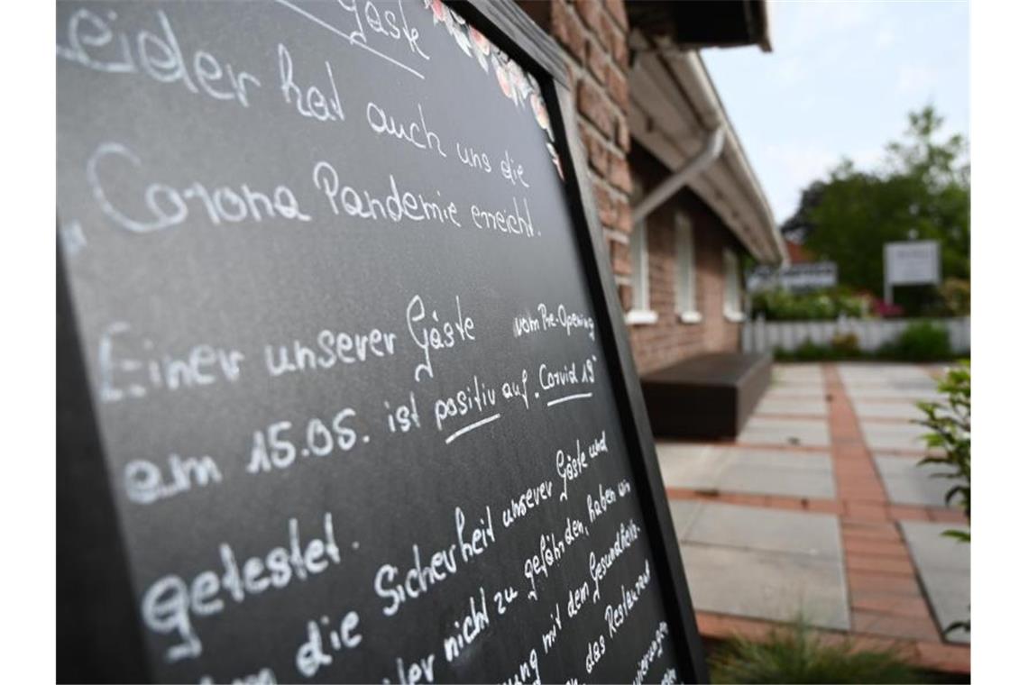 Ein Schild mit der Aufschrift „Leider hat auch uns die Corona Pandemie erreicht“, steht vor dem Restaurant „Alte Scheune“ in Moormerland. Foto: Lars-Josef Klemmer/dpa