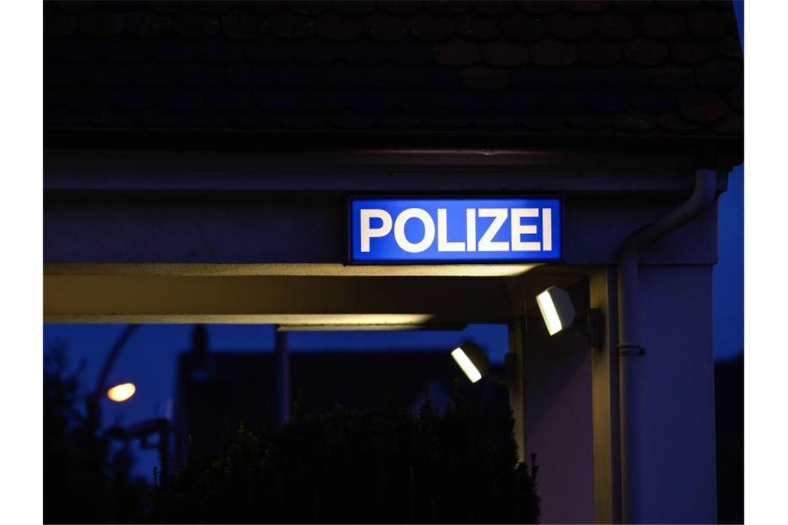 Ein Schild mit der Aufschrift „Polizei“ leuchtet am Eingangsbereich der Polizeistation. Foto: Silas Stein/dpa/Symbolbild