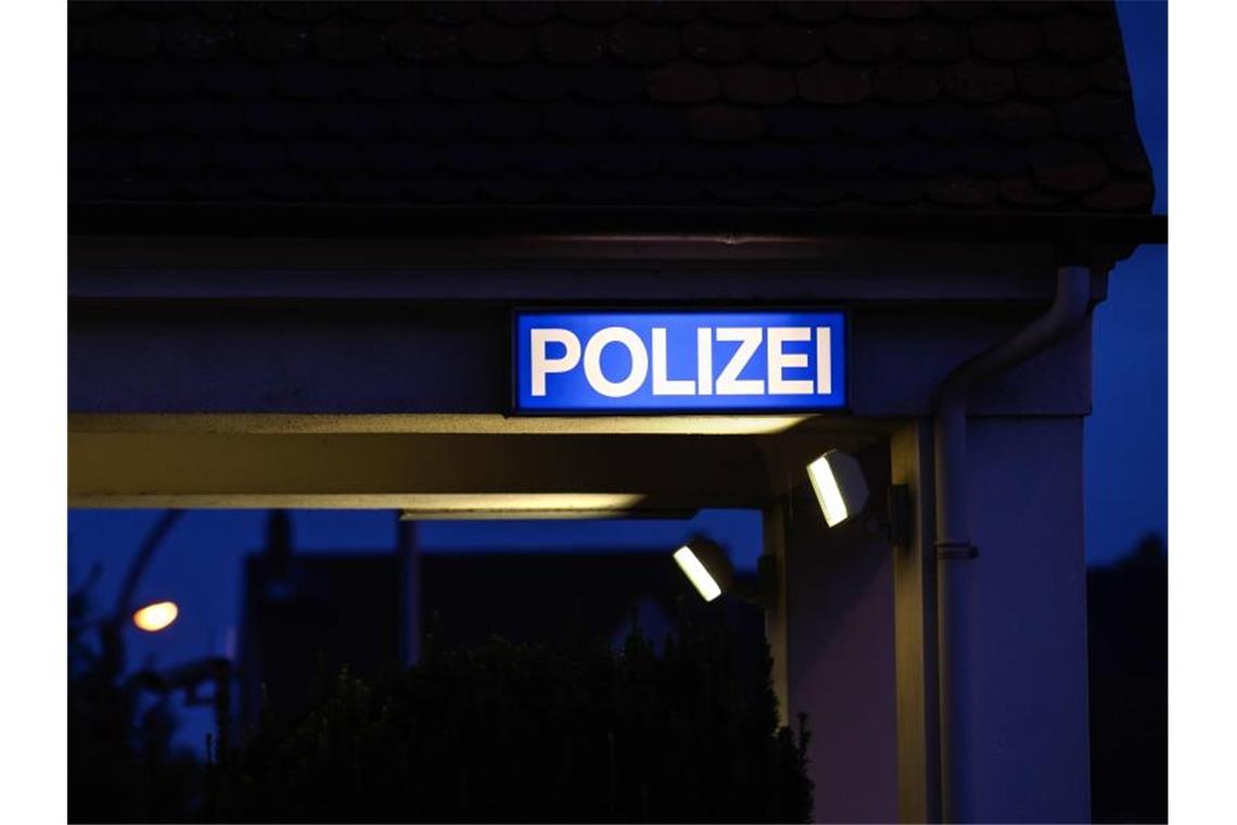 Ein Schild mit der Aufschrift „Polizei“ leuchtet am Eingangsbereich der Polizeistation. Foto: Silas Stein/dpa/Archivbild