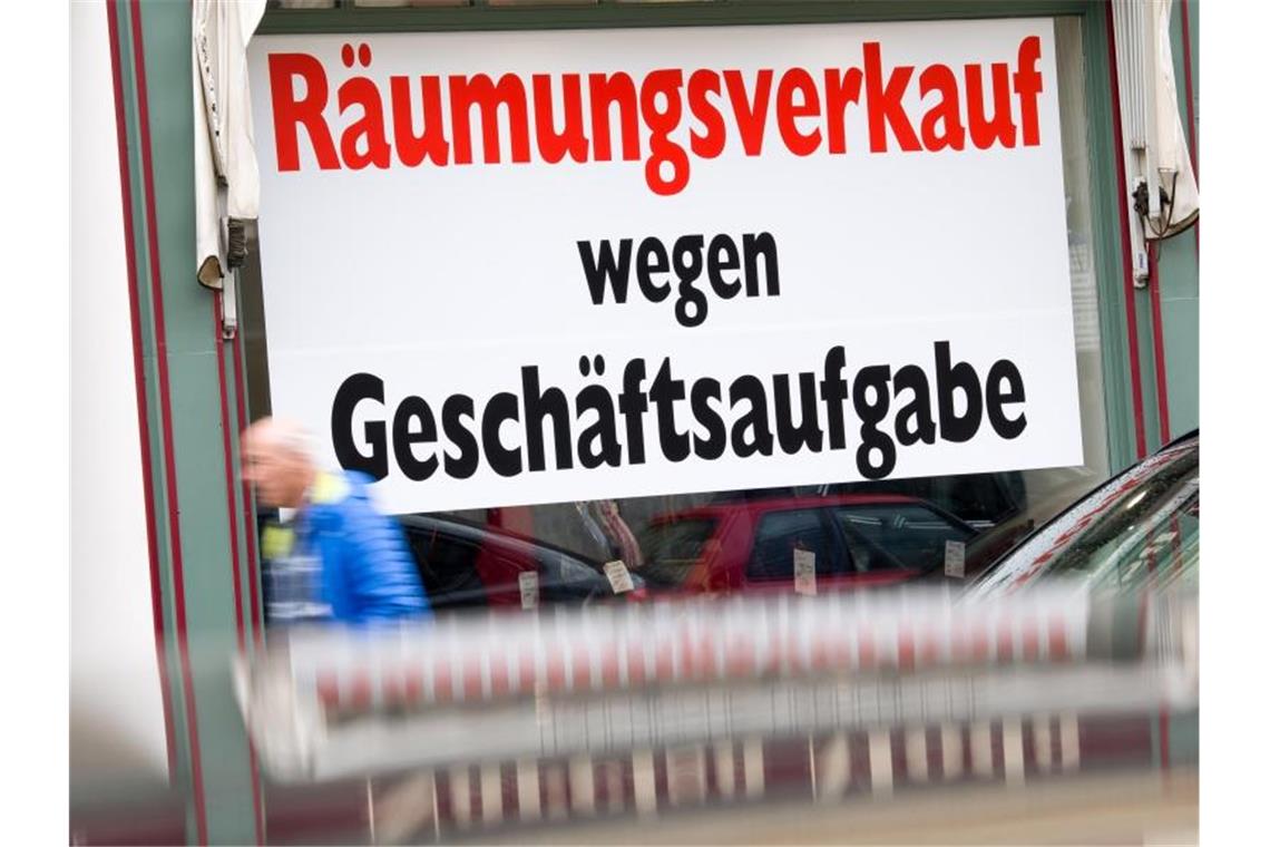 Ein Schild mit der Aufschrift „Räumungsverkauf wegen Geschäftsaufgabe“ hängt im Schaufenster eines Ladengeschäfts in der Münchener Innenstadt. Foto: Peter Kneffel/dpa