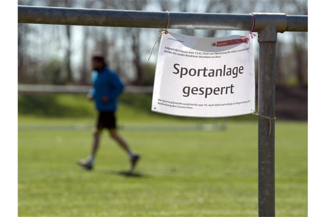 Ein Schild mit der Aufschrift "Sportanlage gesperrt" hängt an einem Geländer. Foto: Federico Gambarini/dpa/Archivbild