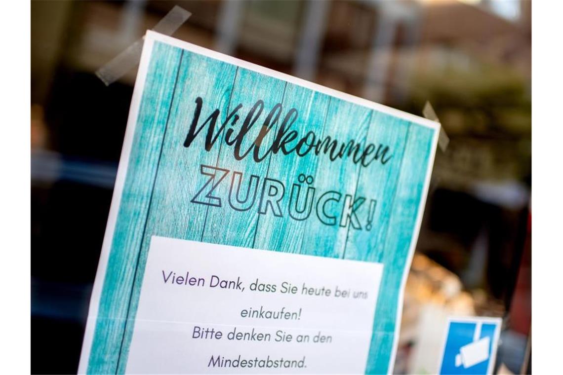 Ein Schild mit der Aufschrift „Willkommen zurück!“ im Schaufenster eines Modegeschäfts. Foto: Hauke-Christian Dittrich/dpa