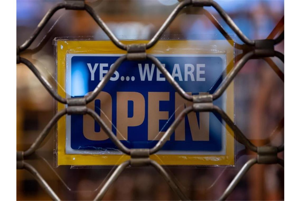 Nach „Frustgipfel“: Altmaier kündigt Nachbesserungen an Ein Schild mit der Aufschrift „Yes...we are Open“ hängt in einem Münchner Geschäft. Foto: Sven Hoppe/dpa
