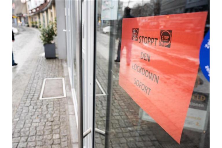 Ein Schild „Stoppt den Lockdown sofort“ hängt in der Eingangstür eines Geschäftes in der Innenstadt von Hannover. Foto: Julian Stratenschulte/dpa