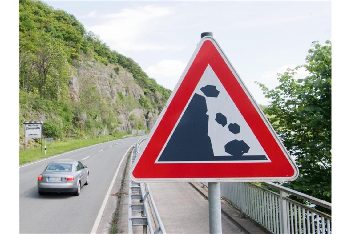 Ein Schild warnt an einer Straße vor Felsstürzen. Foto: Julian Stratenschulte/dpa/Archivbild