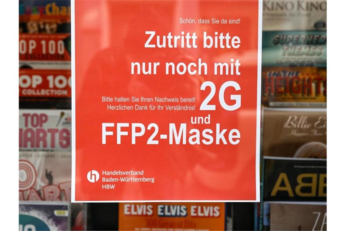 Regierung bleibt bei 2G im Einzelhandel: Wirtschaft drängt Ein Schild weist am Eingang eines Ladens in der Innenstadt auf die Maskenpflicht und die 2G-Regel hin. Foto: Felix Kästle/dpa/Symbolbild