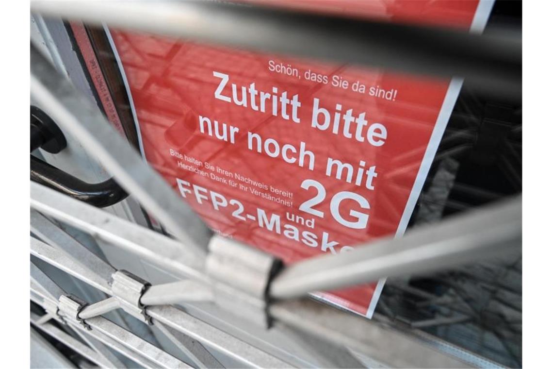 CSU dringt auf Omikron-Check der Corona-Regeln Ein Schild weist am Eingang eines Ladens in der Innenstadt auf die Maskenpflicht und die 2G-Regel hin. (Archivbild). Foto: Felix Kästle/dpa