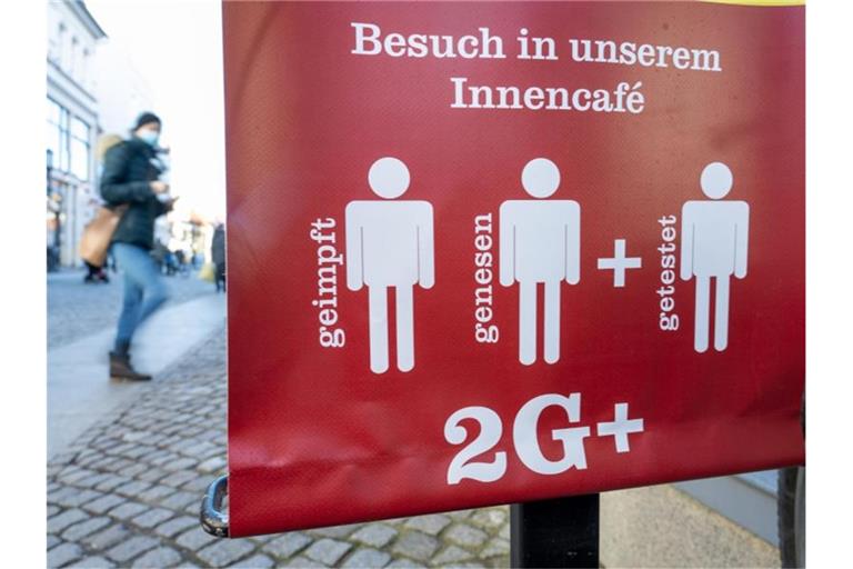 Ein Schild weist auf die 2G Plus Regel in einem Café im Ostseebad auf Rügen hin. Foto: Stefan Sauer/dpa