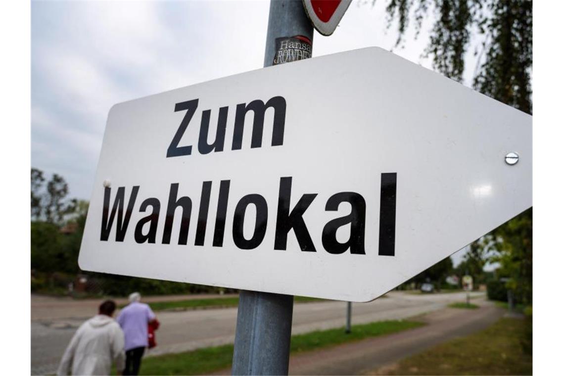 Schon vormittags viele Wähler bei sonnigem Wetter Ein Schild weist den Weg zu einem Wahllokal. Foto: Stefan Sauer/dpa/Symbolbild