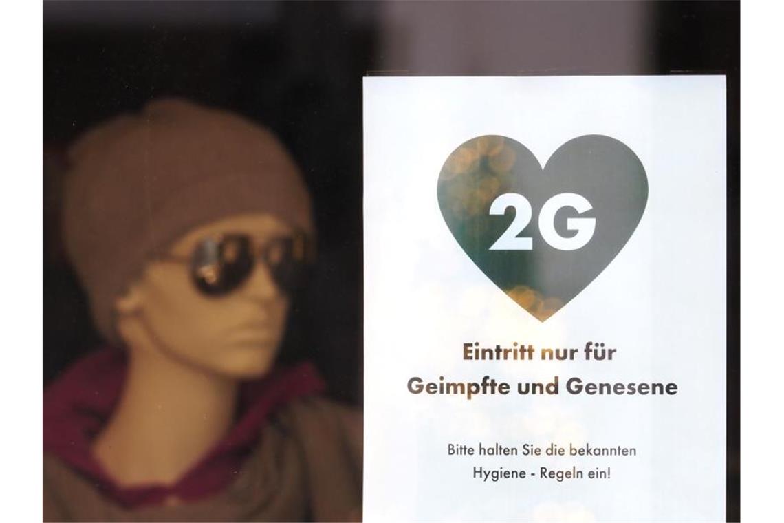 Ein Schild weist die Kunden eines Modegeschäfts in Potsdam auf die 2G-Regel hin. Foto: Soeren Stache/dpa-Zentralbild/dpa