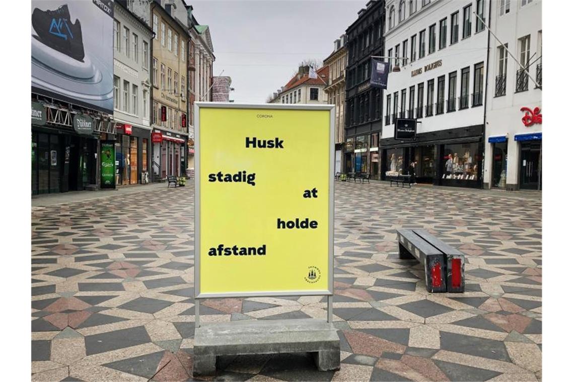 Ein Schild weist in der Fußgängerzone von Kopenhagen auf die Einhaltung der Abstandsregeln hin. Foto: Steffen Trumpf/dpa