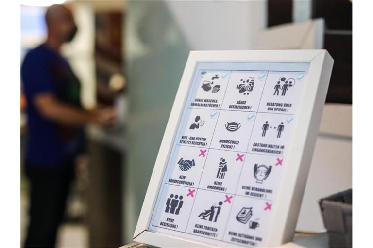 Ein Schild weist Kunden in einem Friseursalon über die einzuhaltenden Corona-Hygienemaßnahmen hin. Foto: Christoph Schmidt/dpa/Archivbild