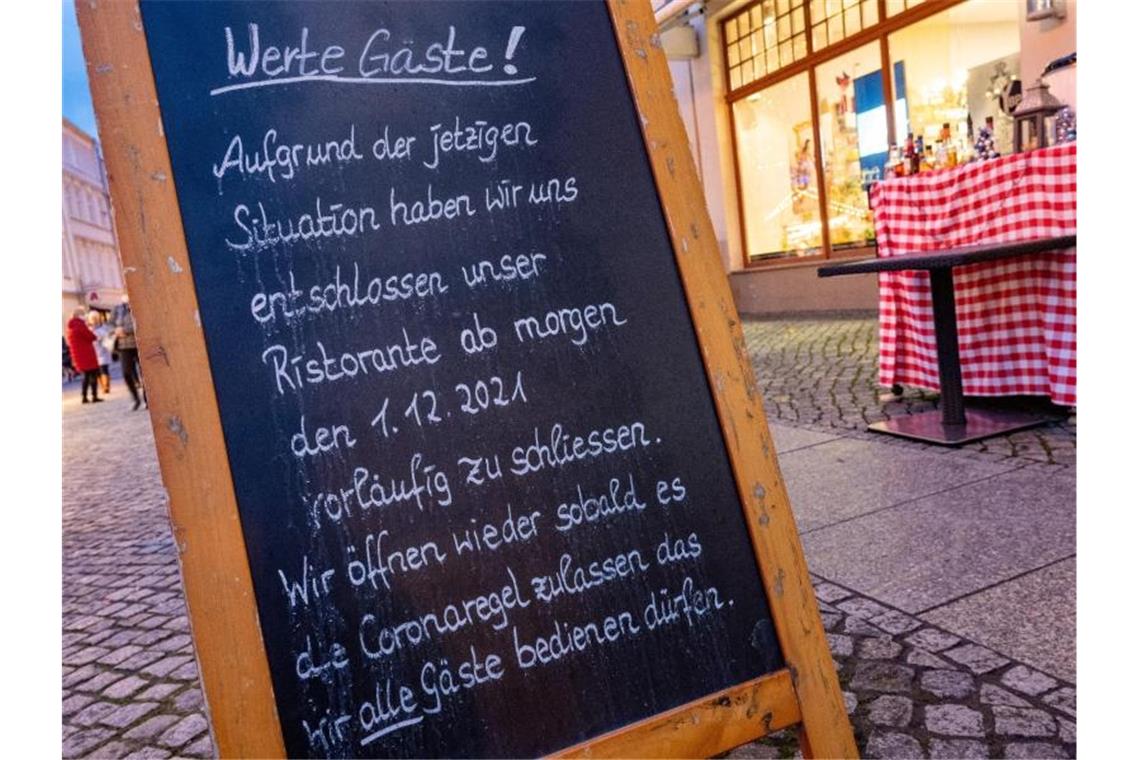 Ein Schild zur Schließung am Eingang zu einem Restaurant am Markt in Greifswald. Foto: Stefan Sauer/dpa