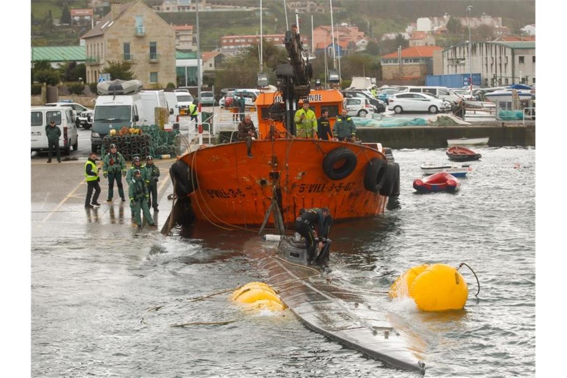 Ein Schlepper der Guardia Civil zieht ein gut 20 Meter langes Drogen-U-Boot aus dem Wasser, das vor der Küste der Region Galicien abgefangen worden war. Foto: Marta Vazquez Rodriguez/Europa Press/dpa