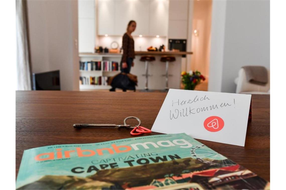 Ein Schlüssel, ein Airbnbmag-Magazin und eine Willkommenskarte liegen in der Wohnung eines Airbnb-Gastgebers. Foto: Jens Kalaene/Archivbild