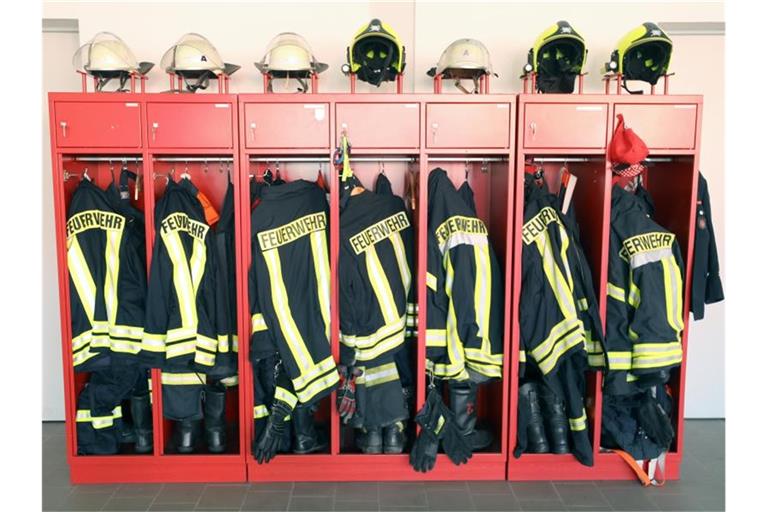 Ein Schrank mit Jacken und Helmen der Feuerwehr ist zu sehen. Foto: Bernd Wüstneck/dpa-Zentralbild/ZB/Symbolbild
