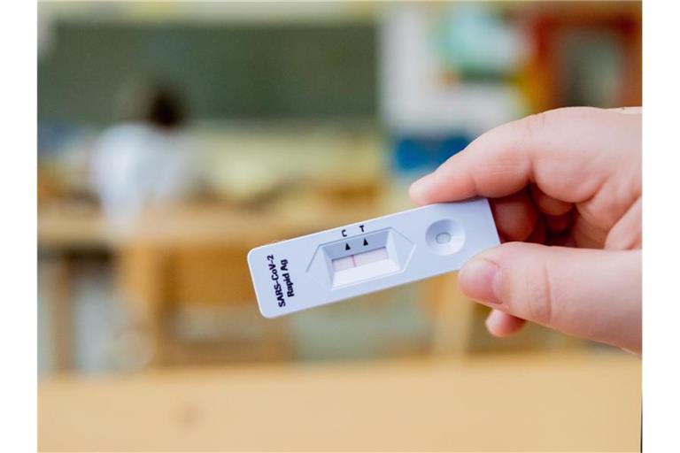 Ein Schüler hält seinen negativen Test in der Hand. Eine Mutter hatte eine Verfassungsbeschwerde gegen die Corona-Regeln an Schulen eingelegt. Foto: Christoph Soeder/dpa