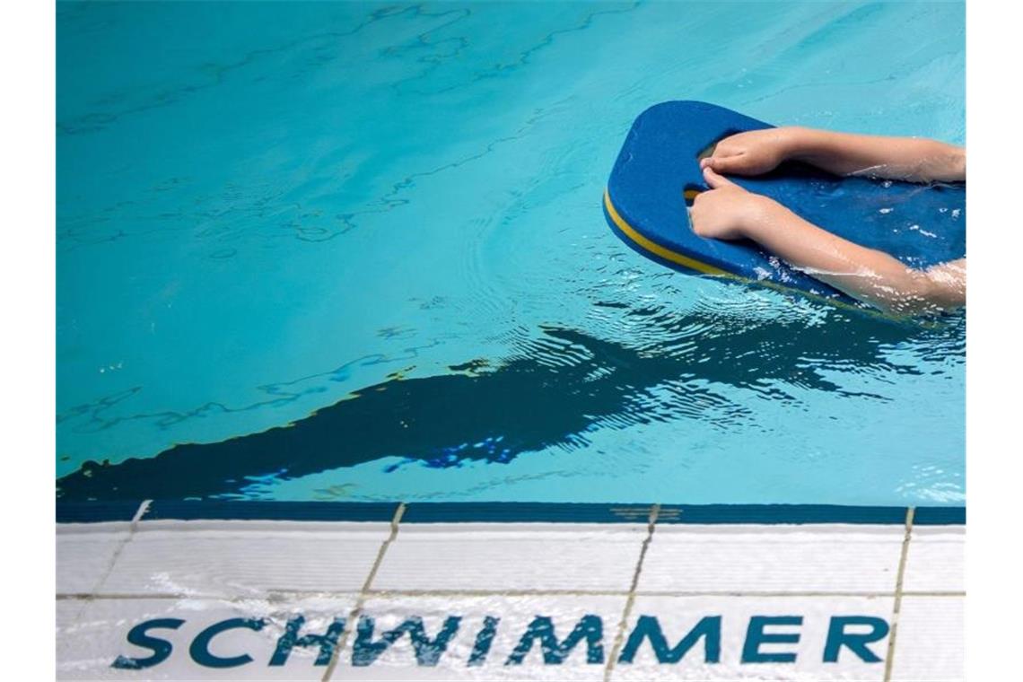 Ein Schüler schwimmt mit einer Schwimmhilfe durch ein Schwimmbecken. Foto: Sina Schuldt/dpa/Symbolbild