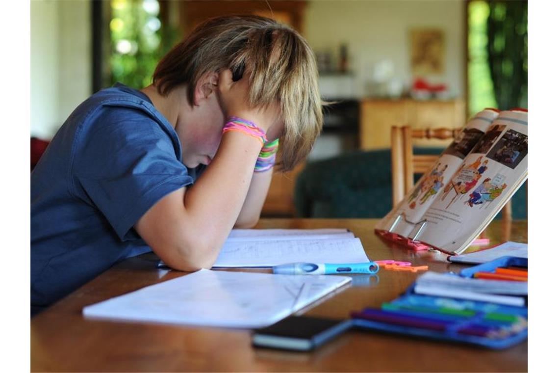 Lehrer können abgehängte Kinder in die Schule bestellen Ein Schüler sitzt zuhause an einem Tisch und lernt. Foto: picture alliance / Julian Stratenschulte/dpa/Archivbild