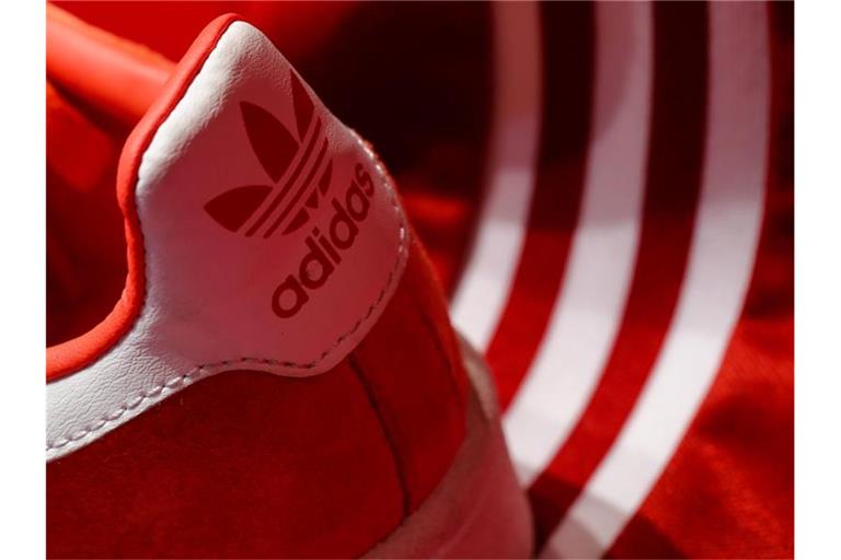 Ein Schuh des Sportartikelherstellers adidas wird am Rande der Hauptversammlung ausgestellt. Foto: Daniel Karmann/dpa