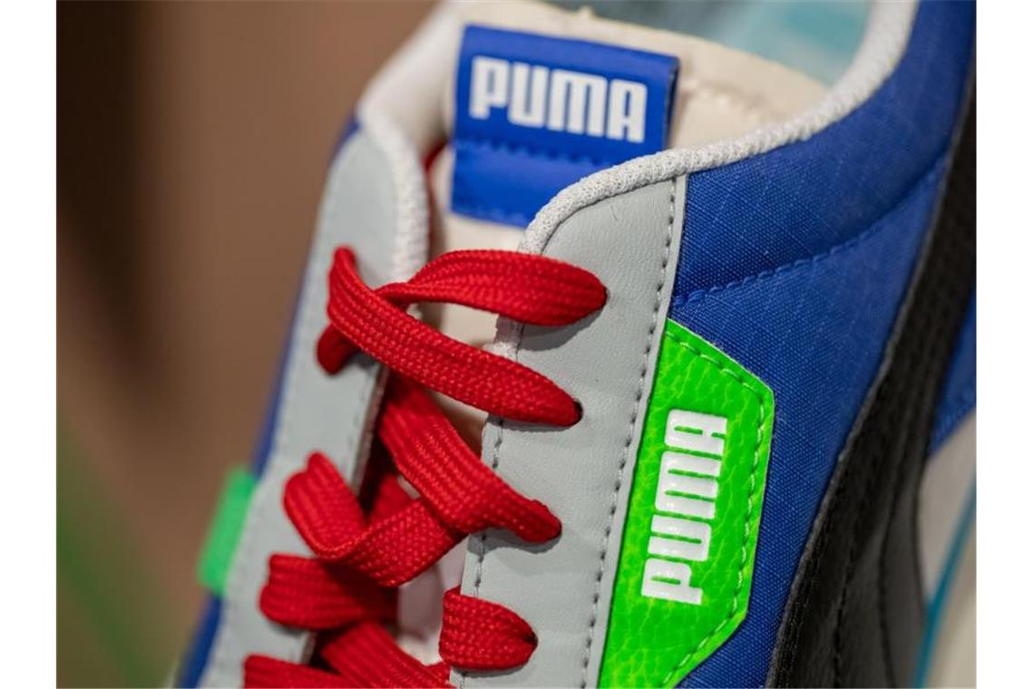 Ein Schuh des Sportartikelherstellers Puma ist am Rande der Bilanz-Pressekonferenz ausgestellt. Foto: Daniel Karmann/dpa
