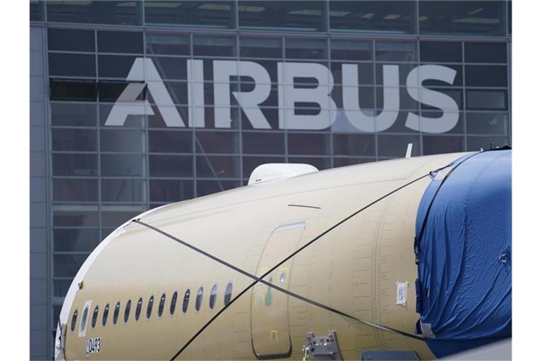 Ein Segment des Flugzeugrumpfes eines Airbus A350 steht vor einer Fertigungshalle auf dem Werksgelände des Flugzeugbauers in Hamburg. Foto: Marcus Brandt/dpa