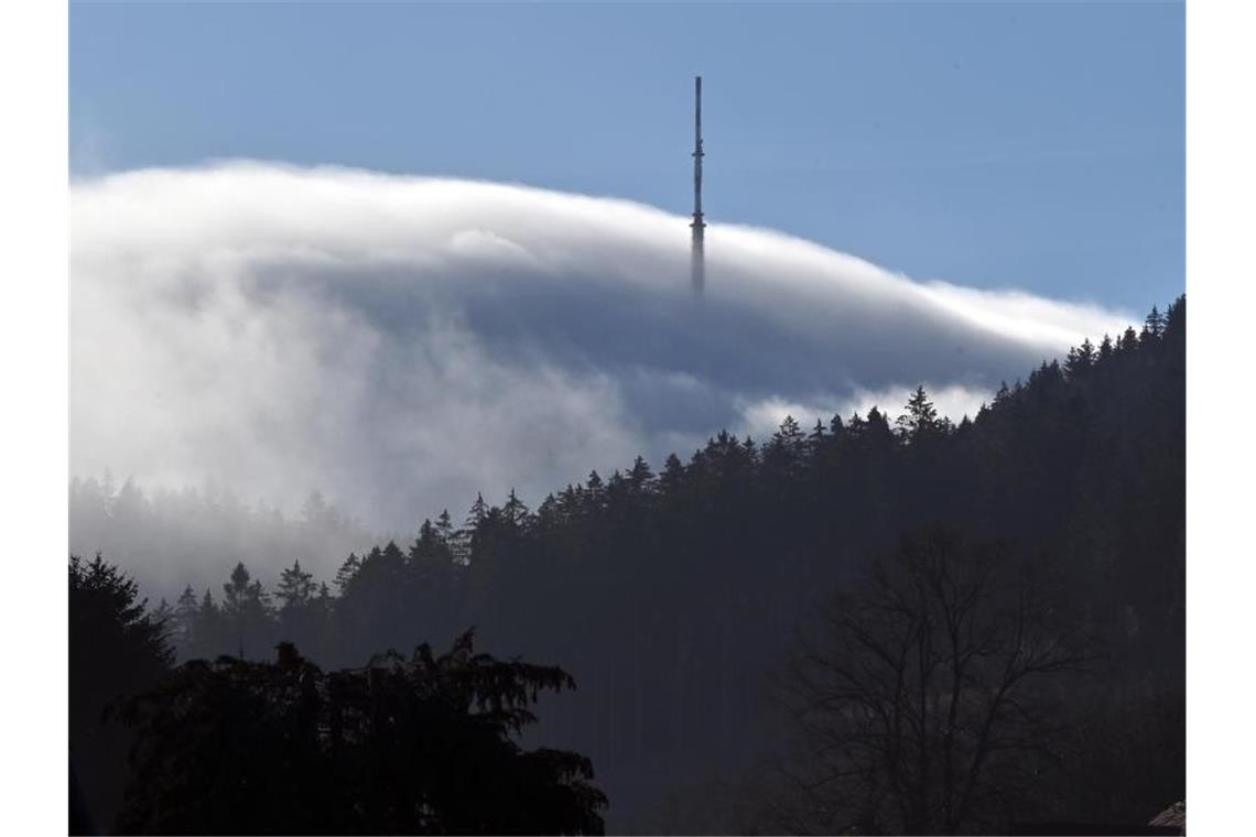 Ein Sendemast ragt an einem Hügel aus dem Nebel. Foto: Martin Schutt/dpa-Zentralbild/dpa/Symbolbild