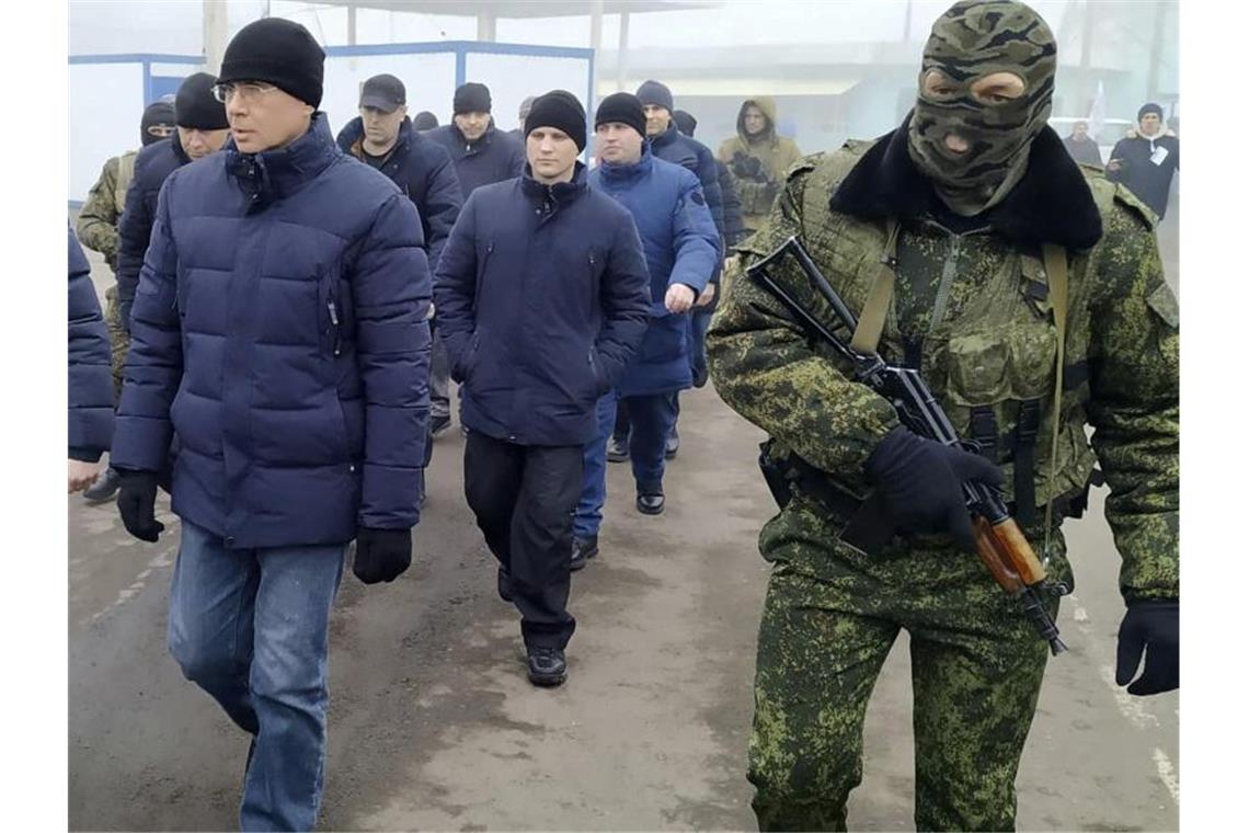 Ein Separatistensoldat begleitet ukrainische Kriegsgefangene zum Kontrollpunkt. Foto: Alexei Alexandrov/AP/dpa