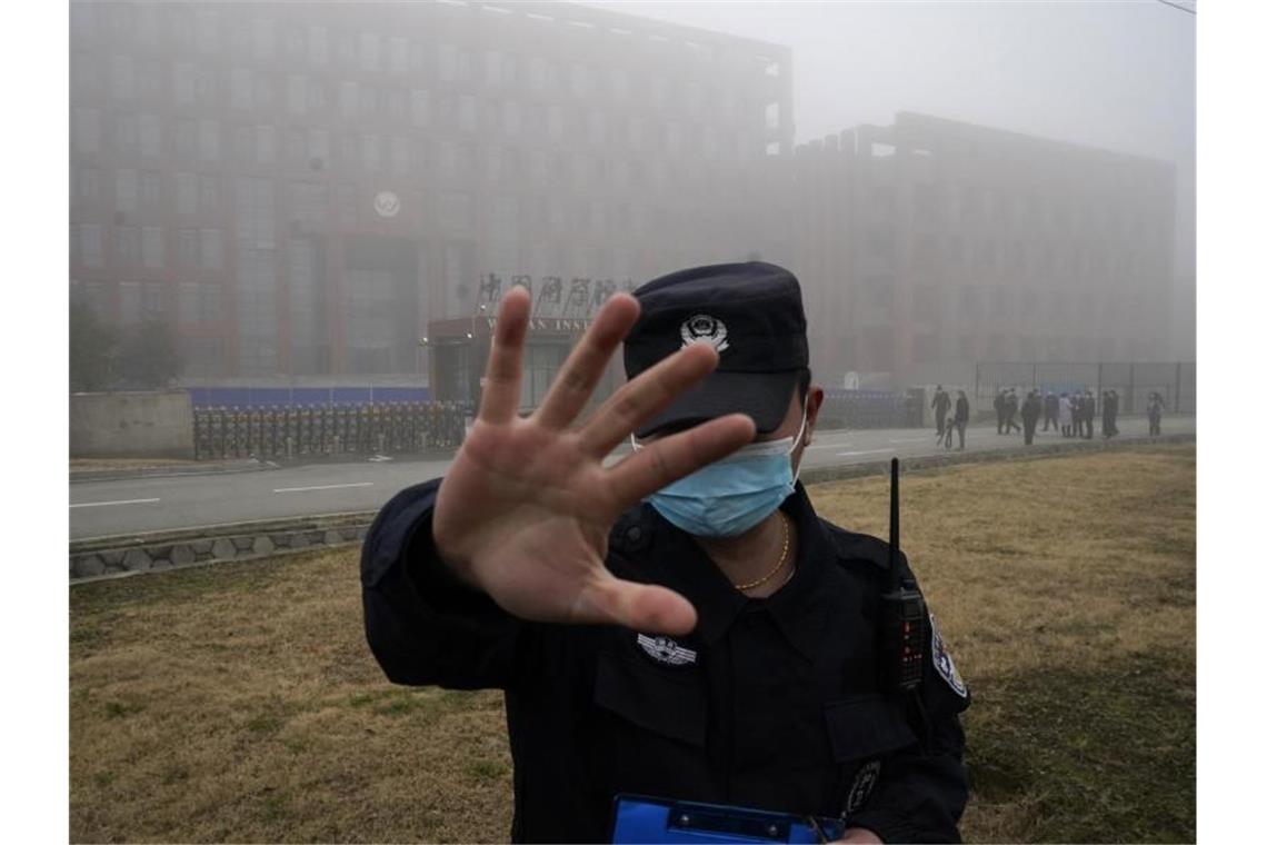 Ein Sicherheitsmann stoppt Journalisten vor dem Institut für Virologie in Wuhan. Foto: Ng Han Guan/AP/dpa