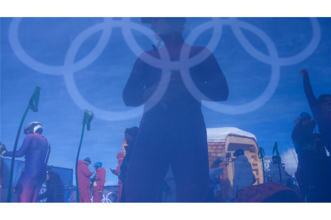 Ein Skifahrer wärmt sich vor dem offiziellen Training für die Abfahrt der alpinen Skifahrer bei den Olympischen Winterspielen 2026 auf.