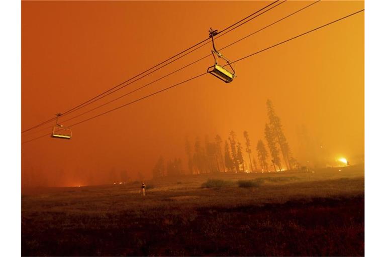 Ein Skilift im Skigebiet Sierra-at-Tahoe vor dem Hintergund des Caldor-Feuers. Foto: Noah Berger/AP/dpa