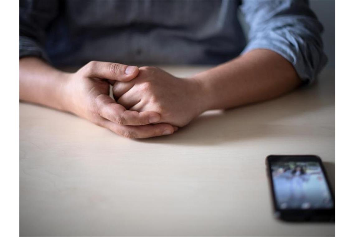 Sextortion und Cybergrooming per Smartphone: Schüler leiden Ein Smartphone liegt vor einem Mann auf dem Tisch. Soziale Medien haben auch eine dunkle Seite. Besonders Kinder und Jugendliche machen immer wieder negative Erfahrungen. Foto: Sina Schuldt