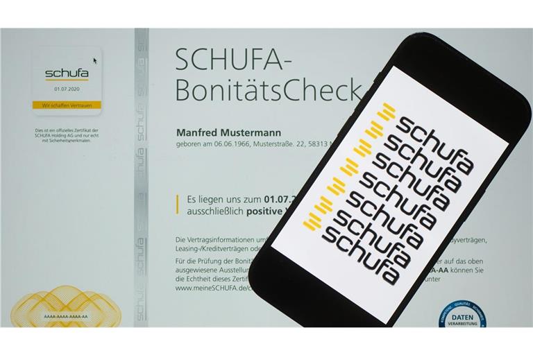 Ein Smartphone mit dem Logo der Wirtschaftsauskunftei Schufa liegt auf einem Display mit einem Musterdokument eines Schufa-Bonitätszertifikat.