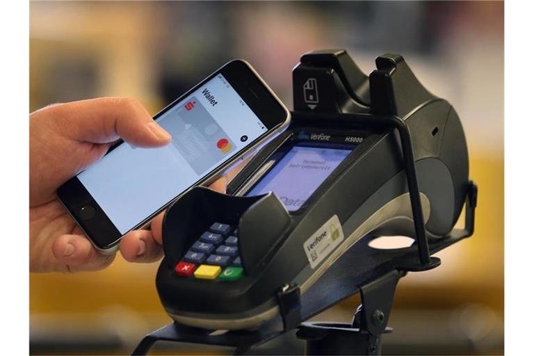 Ein Smartphone wird an den Bezahl-Terminal an der Kasse eines Supermarktes gehalten. Das kontaktlose Bezahlen wird nach Einschätzung der Bundesbank in Deutschland populärer. Foto: Karl-Josef Hildenbrand/dpa