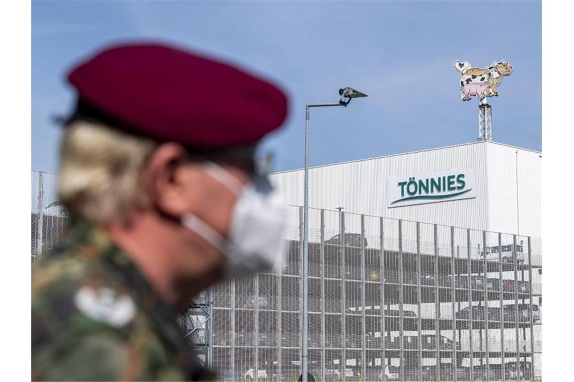 Ein Soldat Bundeswehr vor dem Gebäude der Fleischfabrik Tönnies in Rheda-Wiedenbrück. Foto: David Inderlied/dpa