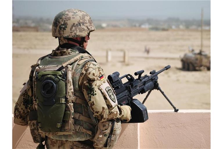 Ein Soldat der Bundeswehr sichert am Stadtrand von Kundus ein Gebäude. Die Deutschen sind grundsätzlich dafür, dass Bundeswehrsoldaten im Ausland eingesetzt werden. Foto: Hannibal Hanschke/dpa