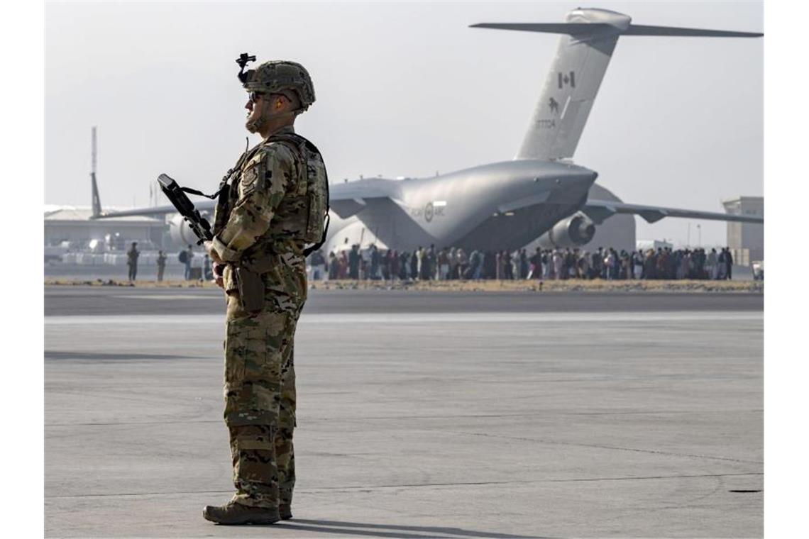 Weiterer Bundeswehr-Flieger evakuiert 205 Menschen aus Kabul Ein Soldat der US-Luftwaffe steht auf dem Hamid Karzai International Airport in Kabul Wache. Vor den Toren des Flughafens stehen Tausende Menschen. Foto: Sra Taylor Crul/U.S. Air/Planet Pix via ZUMA Press Wire/dpa
