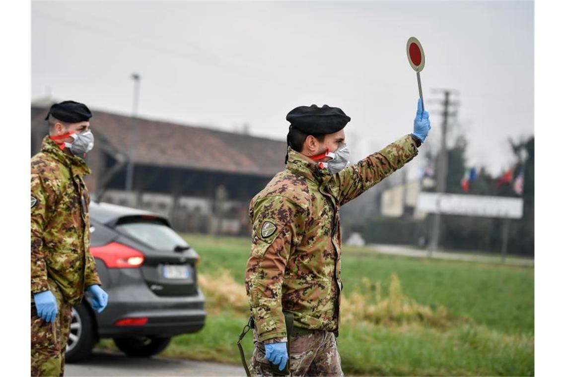 Ein Soldat mit Atemschutzmaske prüft die Ein- und Ausreise in Italien. Foto: Claudio Furlan/LaPresse via ZUMA Press/dpa