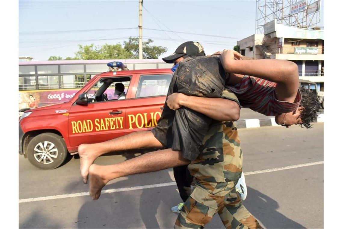 Elf Tote bei Gasleck in indischer Fabrik Ein Soldat trägt einen Jungen nach einem Gasunglück an einer Chemiefabrik in Indien. Foto: Uncredited/AP/dpa