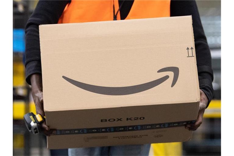 Ein Sortiermitarbeiter von Amazon trägt in einem Verteilzentrum ein Paket. Verbraucherschützer sehen die zunehmende Marktmacht großer Online-Plattformen wie Amazon mit Sorge. Foto: Sebastian Kahnert/dpa-Zentralbild/dpa